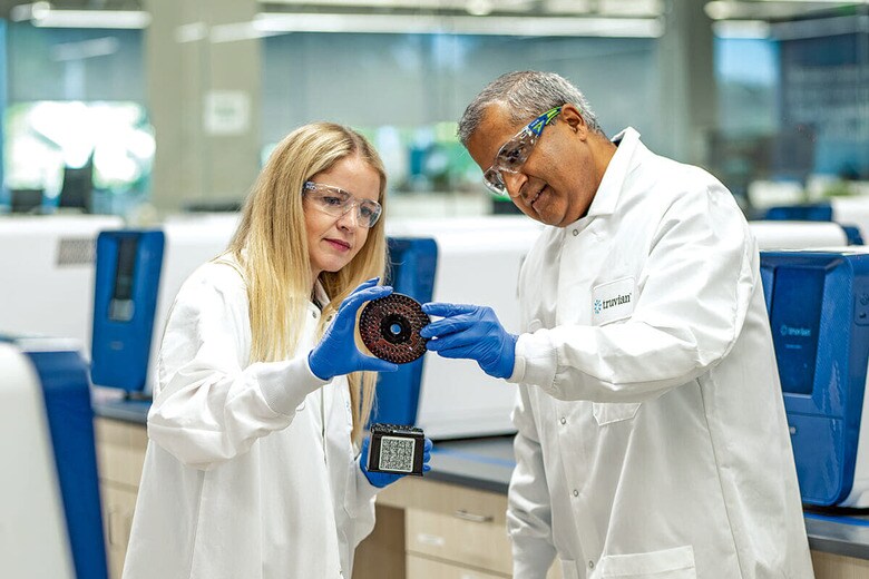 自社の血液検査装置で使う「サポートパック」と分析用ディスクを手にするマリヌッチ（左）とスリニバサン　TRUVIAN