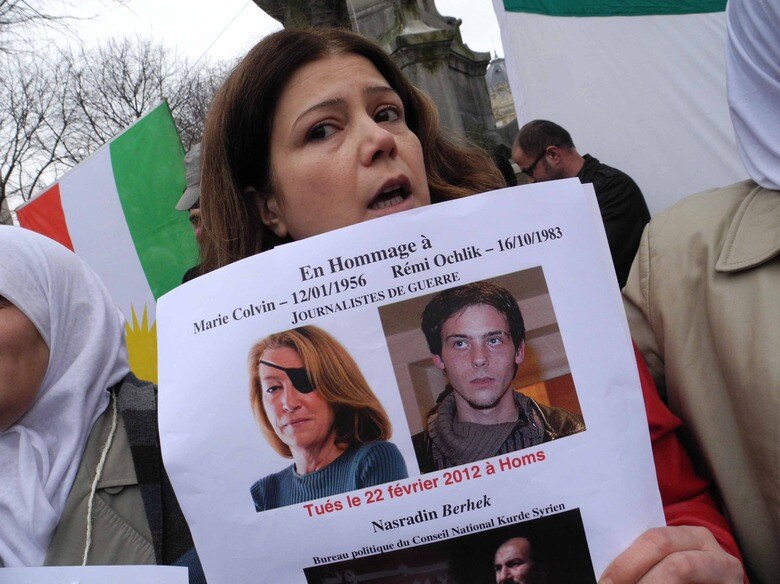 シリアで殺害されたジャーナリストのコルビンらの写真を掲げてアサド政権批判とシリア国民への支援を訴えるデモ参加者（2012年、パリ）　ABD RABBO AMMAR/ABACA－REUTERS