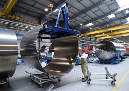 FILE PHOTO: A worker at German manufacturer of silos and liquid tankers, Feldbinder Special Vehicles, moves rolls of aluminium at the company\'s plant in Winsen, Germany, July 10, 2018. Picture taken July 10, 2018. REUTERS/Fabian Bimmer/File Photo