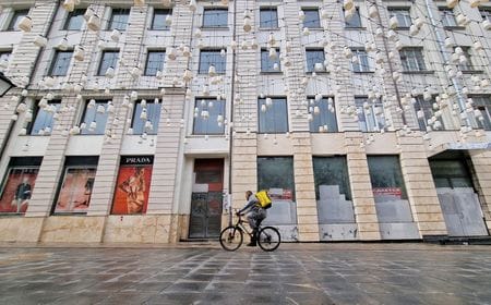 　トランプ氏が１月に米大統領に返り咲き、ウクライナ戦争の早期終結を約束すると、西側企業が大挙してロシア市場に戻ってくるのではないかとの熱気が盛り上がった。しかしそれから３カ月がたち、今では厳しい現実が目の当たりになっている。写真は一時的に閉店した店舗の前を通る人。モスクワで２０２２年５月撮影（２０２５年　ロイター/Shamil Zhumatov）