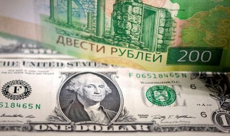 　ロシアルーブルは９日の取引で下落。モスクワ市場では対ドルと対ユーロで最安値を更新した。写真はルーブル紙幣とドル紙幣(２０２２年　ロイター/Dado Ruvic/Illustration)
