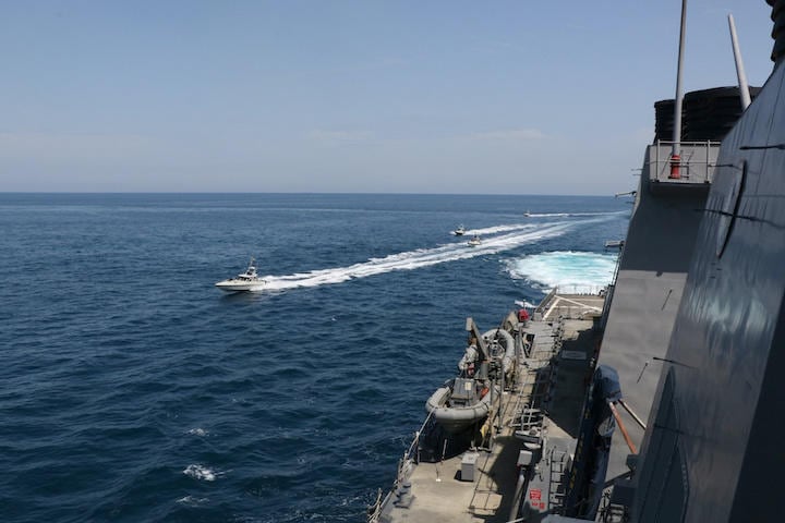 ペルシャ湾で米海軍のミサイル駆逐艦ポール・ハミルトンのすぐそばを通過するイランの高速艇　U.S. Navy/REUTERS