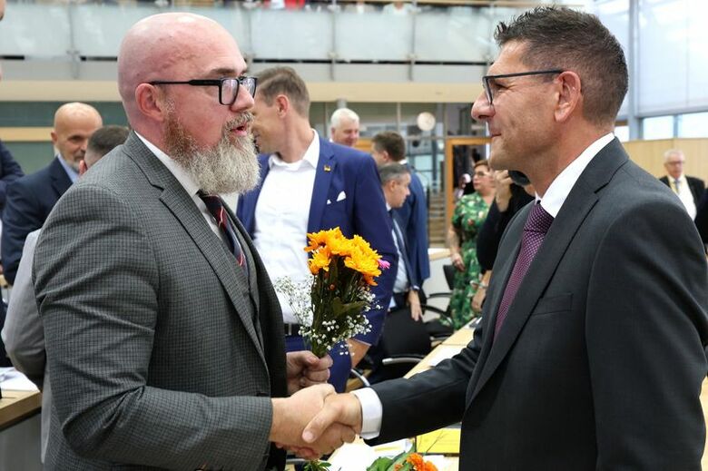 極右政党「ドイツのための選択肢（AfD）」のティルシュナイダー氏と握手する、極左小政党「ザーラ・ワーゲンクネヒト同盟（BSW）」のシュルツェ氏。10月6日、マクデブルクで代表撮影。REUTERS