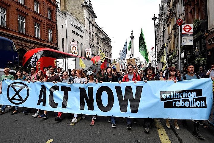 今や、科学的にも裏付けられつつある。飽くなき経済成長の追求は地球上の生命を支える基盤を蝕んでおり、このままの流れが続けば、貧富にかかわらず、どの国も苦い結果を避けることはできそうにない。写真は4月、ロンドンでデモ行進し、気候変動対策を訴える「エクスティンクション・レベリオン」の参加者（2019年　ロイター/Toby Melville）