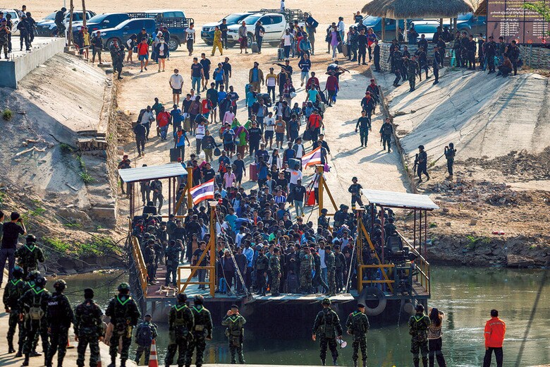 詐欺拠点から解放され、モエイ川を渡ってタイ側に向かう人々（2月12日）　KRIT PHROMSAKLA NA SAKOLNAKORNｰREUTERS