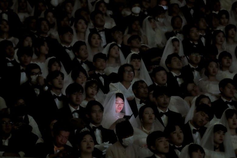 合同結婚式に参加した女性がスマホを見る（2020年、韓国）　AP/AFLO