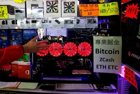 中国の全国人民代表大会（全人代＝国会）は、暗号資産（仮想通貨）に関する新法を可決した。暗号資産の発行に向けた準備となる。写真は香港のモールに展示された仮想通貨をﾏｲﾆﾝｸﾞするコンピューター。２０１８年１月２９日撮影（２０１９年　ロイター/Bobby Yip）