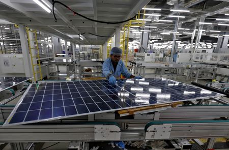 　１２月１０日、インドの再生可能エネルギー省は、政府が手がける事業で使用する太陽電池について、２０２６年６月以降は政府が認可した企業が国内で生産したものに限ると明らかにした。写真はインドのムンドラにある工場で太陽光発電モジュールを組み立てる作業員。４月撮影（２０２４　ロイター／Amit Dave）