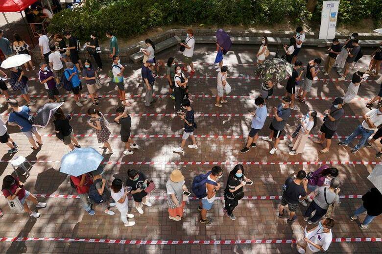 9月に予定される香港の立法会(議会)選挙に向け民主派が7月11─12日に実施した予備選は、投票者数が60万人を超えた。写真は予備選で投票するために行列する人々(2020年　ロイター/Lam Yik)