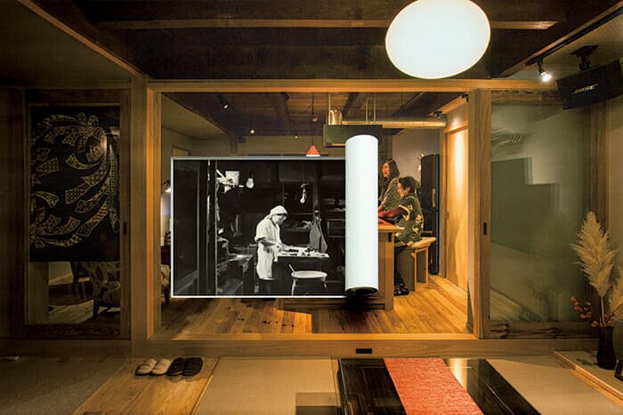 【山陰】真新しいしつらえの宿で旅人と地域住民が集い、酒を酌み交わす。元は1930年代、島根県横田村（現・奥出雲町）に創業した老舗の和菓子屋である松葉屋。業務拡大で町内の別の場所に移転したため、創業者の孫娘が海外のゲストハウスで働いた経験を生かし、旧店舗兼自宅を改修した。町の魅力を語り合う拠点となっている。（古写真協力：内田咲子氏）