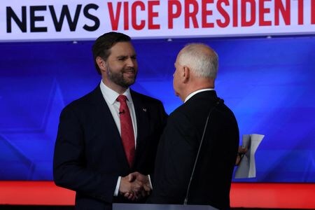 １０月１日、１１月の米大統領選に向け、副大統領候補によるテレビ討論会が開かれた。写真は討論会で握手する民主党候補のウォルズ・ミネソタ州知事（右）と共和党候補のバンス上院議員。ニューヨークで撮影（２０２４年　ロイター/Mike Segar）