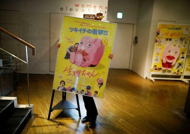 赤い唇と赤いパンツが印象的な「生理ちゃん」は、日本の漫画のキャラクターとして生まれ、最近映画化もされた。写真は上映館で映画のポスターを運ぶスタッフ。12月13日、東京で撮影（2019年　ロイター/Issei Kato）