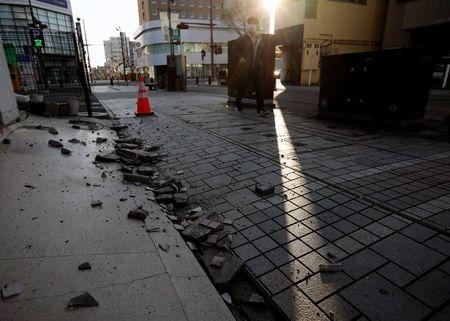 福島県沖を震源とする震度６強の地震発生を受けて、半導体大手のルネサスエレクトロニクスや、ビール大手のキリンホールディングス、アサヒグループホールディングスが一部工場の操業を停止している。写真は地震で損壊した、ビルの外壁。福島県いわき市で２月１４日撮影（２０２１年　ロイター/Issei Kato）