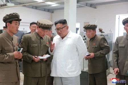 　７月１８日、ロシアのマツェゴラ駐北朝鮮大使は、国連安全保障理事会に北朝鮮制裁の緩和を提起することが論理的との考えを示した。写真は機械工場を視察する金朝鮮労働党委員長(中央）。朝鮮中央通信提供(２０１８年　ロイター)