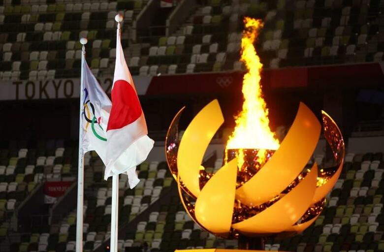 異例の無観客開催となった東京五輪は、猛暑の中で行われた17日間の熱戦が閉幕する。写真は国立競技場に灯された聖火。7月23日撮影（2021年　ロイター/Kai Pfaffenbach）