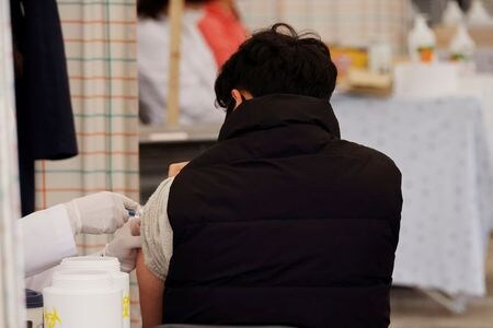 　１０月２２日、韓国の保健当局者は、若者と高齢者１９００万人を対象とした無料のインフルエンザ予防接種プログラムを中止しない考えを示した。写真はソウルで予防接種を受ける様子。２１日撮影（２０２０年　ロイター／Kim Hong-Ji）
