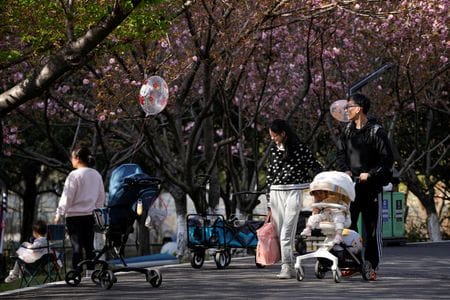 　３月５日、中国政府は、出生率向上に向けた支援策を拡充すると共に、年金給付額引き上げや私的年金制度の導入などで増加する高齢者を支援する方針を示した。写真は赤ちゃんを乗せたベビーカーを押す両親。中国の上海で昨年４月撮影（２０２４　ロイター／Aly Song）