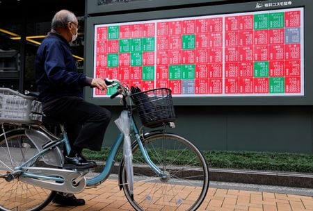 株価ボードを見る男性。2025年10月21日、都内で撮影。REUTERS/Manami Yamada