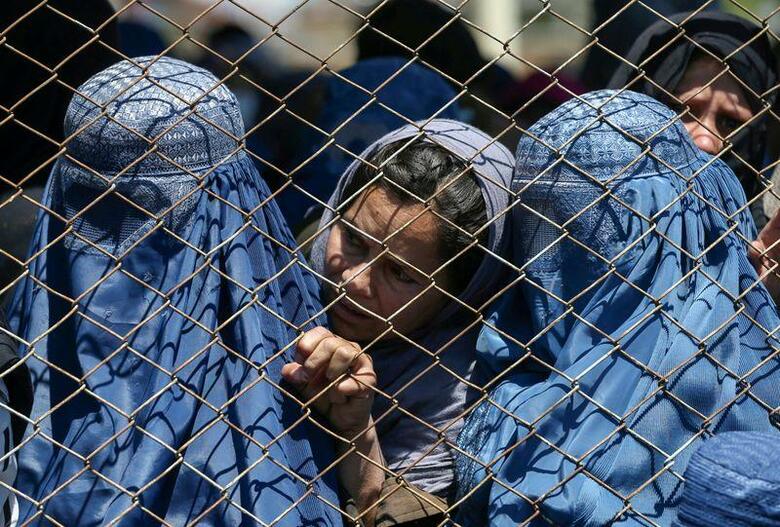 アフガニスタンでイスラム主義組織・タリバンの支配が終わった20年前、同国の女性と少女らは夢のまた夢だった自由を得た。タリバンが再び政権を掌握した今、彼女らはその自由を失わないため懸命に闘おうとしている。写真は昨年4月、カブールで政府による小麦の配給を待つ女性たち（2021年　ロイター）