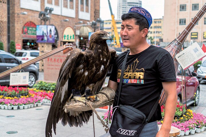 観光客にタカを披露するカザフ人（新疆ウイグル自治区ウルムチ）　Zhang Peng-Lightrocket/GETTY IMAGES