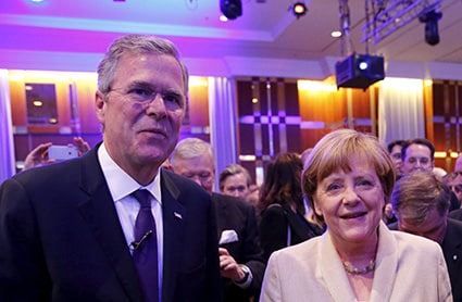 ベルリンでメルケル独首相とツーショットを撮るジェブ・ブッシュ Fabrizio Bensch-REUTERS