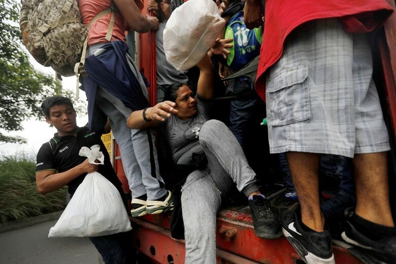 １０月１８日、中米ホンジュラスやグアテマラなどから米国への移住を目指す数千人の集団が北上を続けている問題で、トランプ大統領は、メキシコ政府が移動を阻止しない場合、米軍を展開し南部国境を閉鎖する考えを示した。写真はグアテマラのエスクイントラで、米国を目指してトラックに乗り込むホンジュラス移民ら（２０１８年　ロイター/Edgard Garrido）