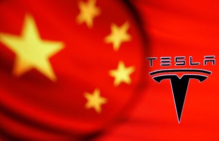 ３月８日、 中国乗用車協会（ＣＰＣＡ）は、米電気自動車（ＥＶ）大手テスラが２月に販売した中国製自動車は５万６５１５台だったと発表した。写真はテスラのロゴと中国旗のイメージ。２０２１年１月撮影（２０２２年　ロイター/Dado Ruvic）