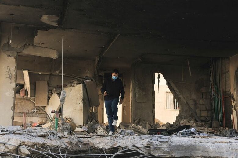 レバノンの首都ベイルート南部郊外の空爆現場を歩く男性。２８日撮影。REUTERS/Raghed Waked