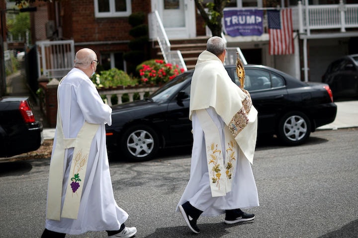 コロナ対策で教会が閉鎖の間、信者の家を訪ねて歩くカトリックの助祭（5月24日、ニューヨーク市）　Mike Segar-REUTERS