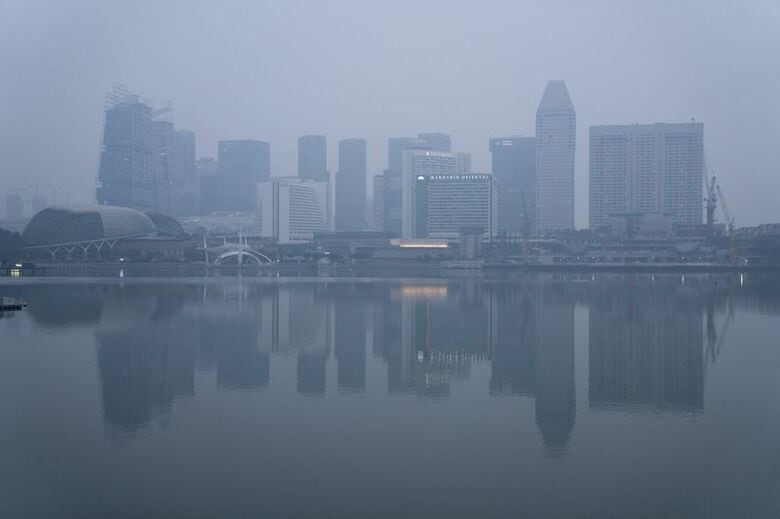 写真はインドネシアの森林火災による煙霧に覆われた建物群。2026年10月13日、シンガポールで撮影。REUTERS/Kokkai Ng