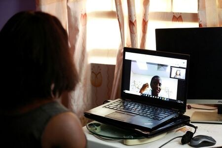 　９月７日、新型コロナウイルスのパンデミック（世界的な大流行）が続く中、世界中で医療のあり方に大きな変化が生じており、アフリカでも医者の診察は対面ではなくオンラインによる遠隔の問診で行われるケースが増えている。写真は、ナイジェリアの首都アブジャで医者とビデオチャットをする、慈善団体調査員のロベス・メティボバさん。８月３１日撮影（２０２０年　ロイター/Afolabi Sotunde）