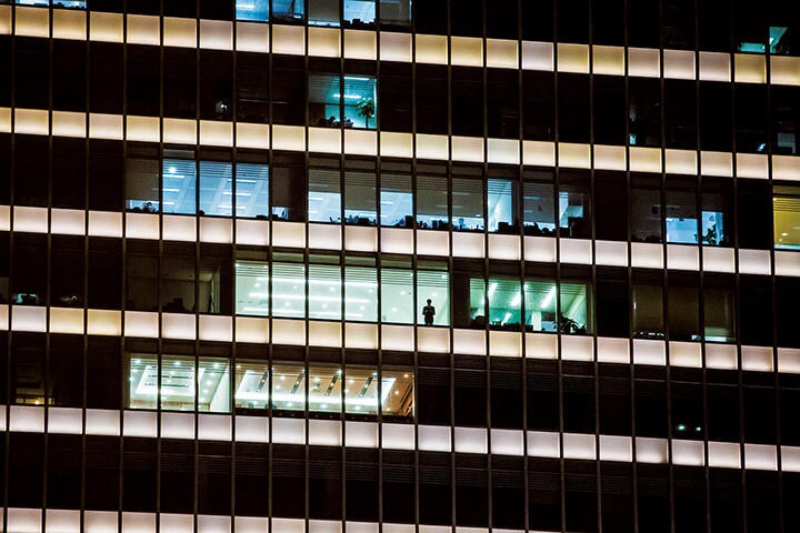深夜、オフィスビルの窓辺にたたずむ。成長神話に陰りも（上海）　QILAI SHEN-BLOOMBERG/GETTY IMAGES