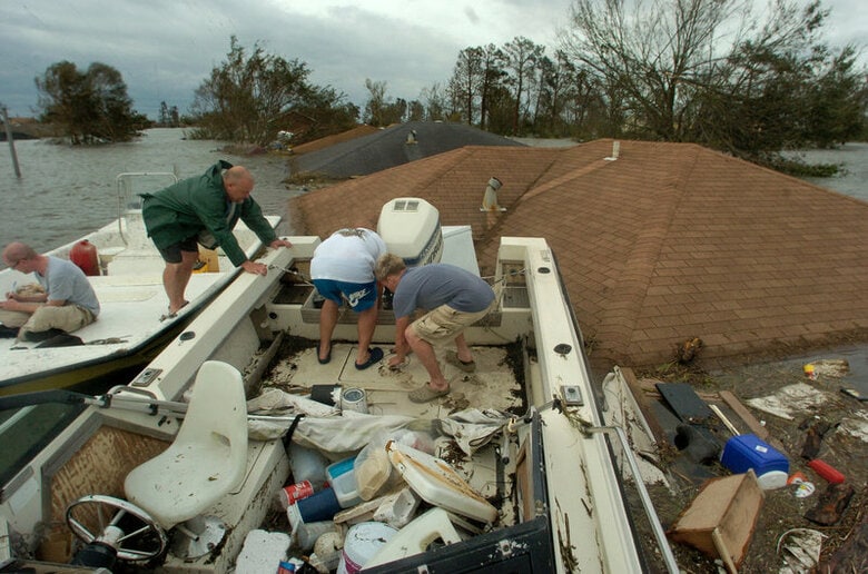 ８月３０日、米テキサス州ヒューストンで大型ハリケーン「ハービー」の避難所として使われているコンベンションセンターで、カトリーナを体験したリアン・バーバーさんと出会った。カトリーナの教訓は生かされているのか。写真左は、カトリーナの被災地を取材するブライアン・テブノ記者。ルイジアナ州セントバーナード郡で２００５年８月撮影。提供写真（２０１７年　ロイター/Courtesy of Ted Jackson/The Times-Picayune/Handout via REUTERS）