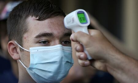 米疾病対策センター（ＣＤＣ）は２２日、新型コロナウイルスの国内新規感染者のうち、変異ウイルス系統「ＪＮ．１」の感染割合が１９日時点で８５．７％程度に上るとの推計を示した。写真は体温を測る学生。米バージニア州で２１年６月撮影。（2024年 ロイター/Evelyn Hockstein/File photo）