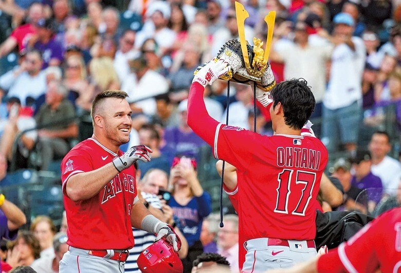 6月のコロラド・ロッキーズ戦で、本塁打を放ったトラウト（左）にかぶとをかぶせようとする大谷　スポニチ/AFLO