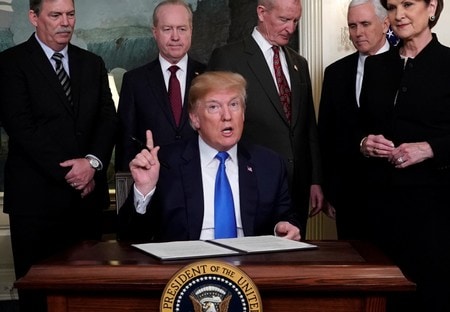 ３月２８日、「賭け」を生業とする米ウォール街の金融マネジャーたちにとって、トランプ米大統領の通商面での対中強硬姿勢は、高額な賭け金がかかったポーカーの手のように見えている。写真はホワイトハウス２２日、中国が米国の知的財産権を侵害しているとして最大６００億ドルの輸入品への課税方針を署名するトランプ米大統領（２０１８年　ロイター/Jonathan Ernst）