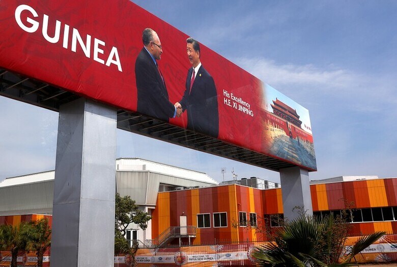 １１月１５日、戦略的な要衝に位置するパプアニューギニアを巡り、オーストラリアと中国が火花を散らしている。写真は、握手する中国の習近平国家主席（右）とパプアニューギニアのオニール首相を写真を使ったバナー。首都ポートモレスビーで撮影（２０１８年　ロイター/David Gray）