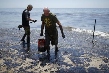 ５月２２日、石油パイプラインの破損で米加州沿岸に原油が流出、復旧に数カ月かかる可能性。写真は２０日に撮影されたボランティアの男性（２０１５年　ロイター／Lucy Nicholson）