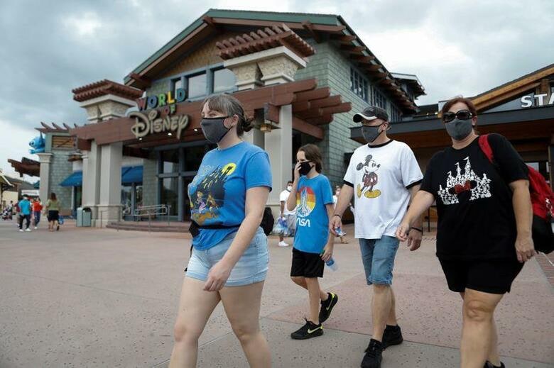 新型コロナウイルスの影響で休園が続いていた米フロリダ州の「ディズニーワールド」が、約4カ月ぶりに営業を再開した。写真はマスクをつけた訪問者ら(2020年　ロイター/Octavio Jones)