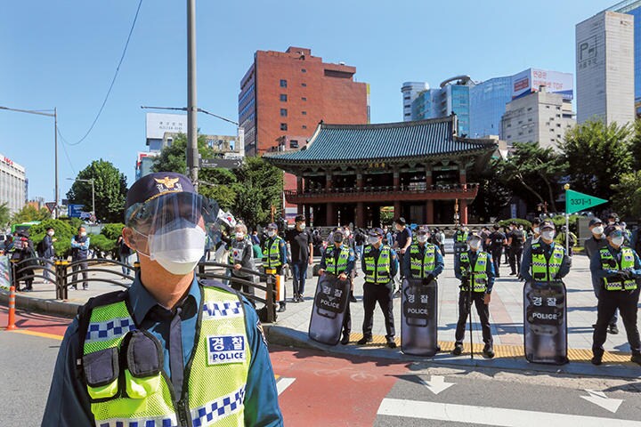 マスクとフェイスシールドを着用して警備に立つソウルの警察官（10月9日）　AP/AFLO