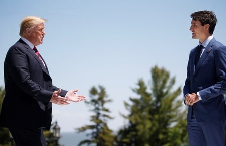 　６月３０日、米ホワイトハウスのサンダース報道官は、トランプ米大統領とカナダのトルドー首相が２９日遅くに電話会談し、通商など経済問題について協議したと明らかにした。写真はＧ７首脳会議で会話する米加両首脳。ケベック州で６月に撮影（２０１８年　ロイター／Leah Millis）