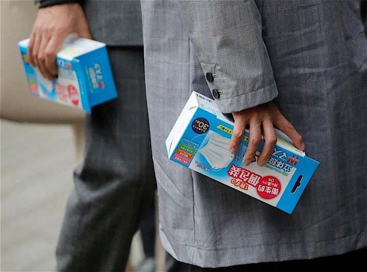 菅義偉官房長官は記者会見で、政府が昨日開催した新型肺炎についての専門会議で、感染拡大を防止するために大規模な集会・イベントを自粛すべき、との意見は出なかったと報告した。写真は新型肺炎予防のためにマスクを購入する人。Issei Kato - REUTERS