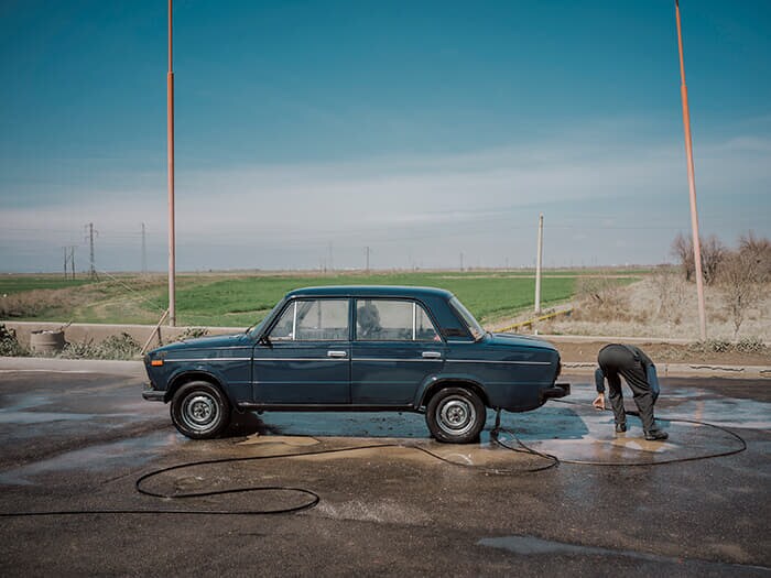 ロシア車ラーダを洗う男性。維持費や修理費が格安で済むラーダはナヒチェバンで一番人気の車種