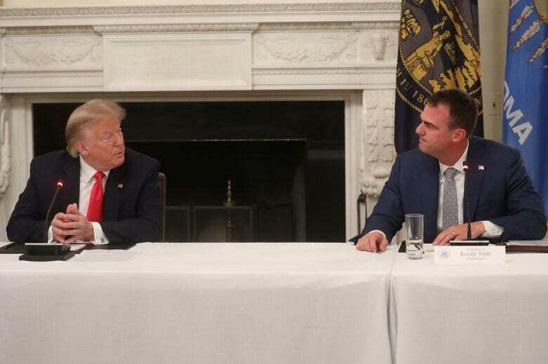 米オクラホマ州のケビン・スティット知事(右)は15日、新型コロナウイルス検査で陽性反応が出たと発表した。分かっている限りでは、米州知事のコロナ感染は今回が初めて。ホワイトハウスで6月撮影(2020年　ロイター/LEAH MILLIS)