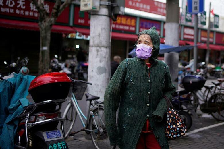 中国国家衛生健康委員会が14日公表したデータによると、中国本土の新型コロナウイルス新規感染状況を巡り、海外から入国した感染者の数が13日に国内感染者数を初めて上回った。写真はマスクをつけた女性。13日に上海で撮影（2020年　ロイター/Aly Song）