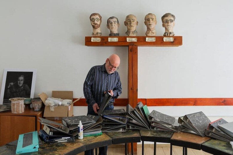 屋外に置かれたごみ箱の近くには、東西冷戦終結を描いたポスターが捨てられている。写真は書類を整理するサハロフセンターのヴィヤチェスラフ・バフミン代表。モスクワで撮影（2023年　ロイター/Evgenia Novozhenina）