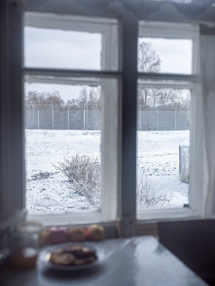 ゴリシェバの住宅のキッチンの窓から見えるフェンス。ロシアとの国境はわずか数百メートル先だ