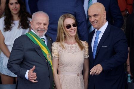 　米政府は２２日、ブラジルのボルソナロ前大統領の裁判に関与したモラエス最高裁判所判事の妻に制裁を課したほか、高官６人のビザを剥奪した。写真は２０２４年９月、独立記念日の祭典でポーズを取るブラジルのルラ大統領とモラエス判事夫妻（２０２５年　ロイター/Adriano Machado）