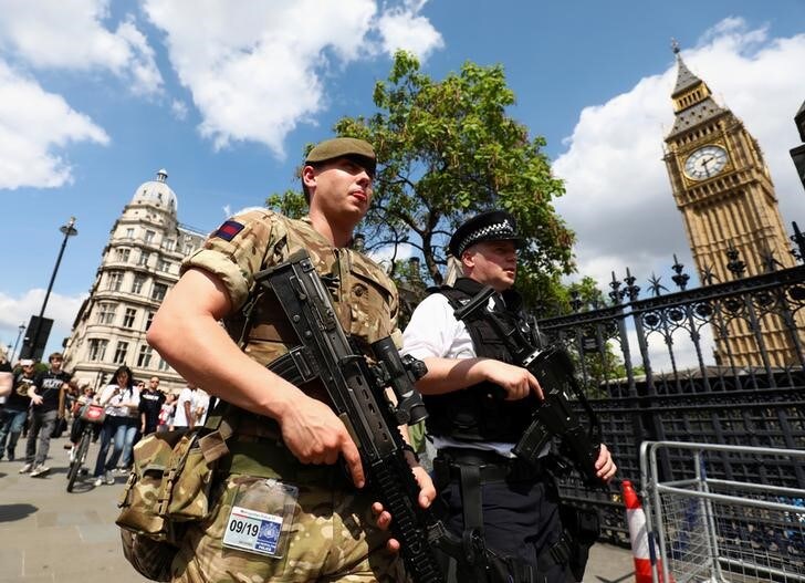 ５月２４日、２２日に英マンチェスターのコンサート会場で発生した自爆攻撃について、警察は２４日、実行犯のサルマン・アベディ容疑者（２２）の父や弟を含む数人の容疑者を拘束した。写真は２４日、ロンドンで英議会などを警備する英軍兵士と警察官（２０１７年　ロイター/Neil Hall）