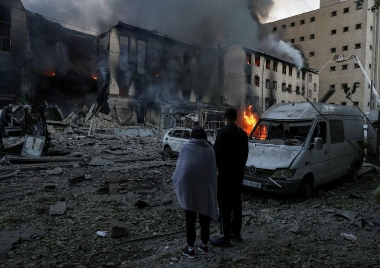 写真はロシアのミサイル攻撃現場に立つ住民。ウクライナの首都キーウで8日撮影。REUTERS